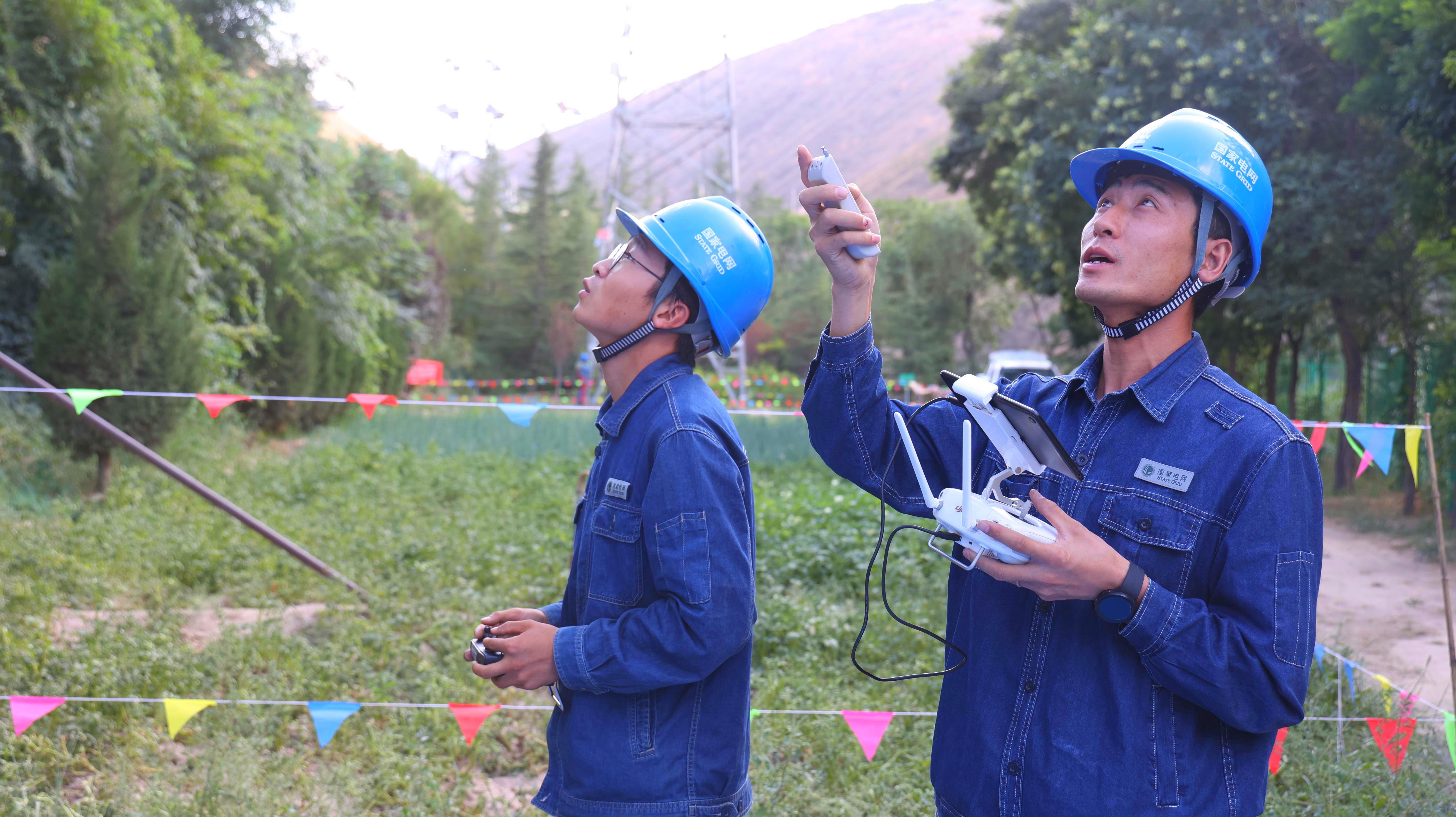 8月25日，國(guó)網(wǎng)蘭州供電公司工作人員在蘭州石板山輸電線路技能培訓(xùn)基地使用“‘歐姆雙翼式’無(wú)人機(jī)接觸式驗(yàn)電器及接地裝置”完成高空輸電線路的接觸式驗(yàn)電及接地。李小東攝 (1).jpg